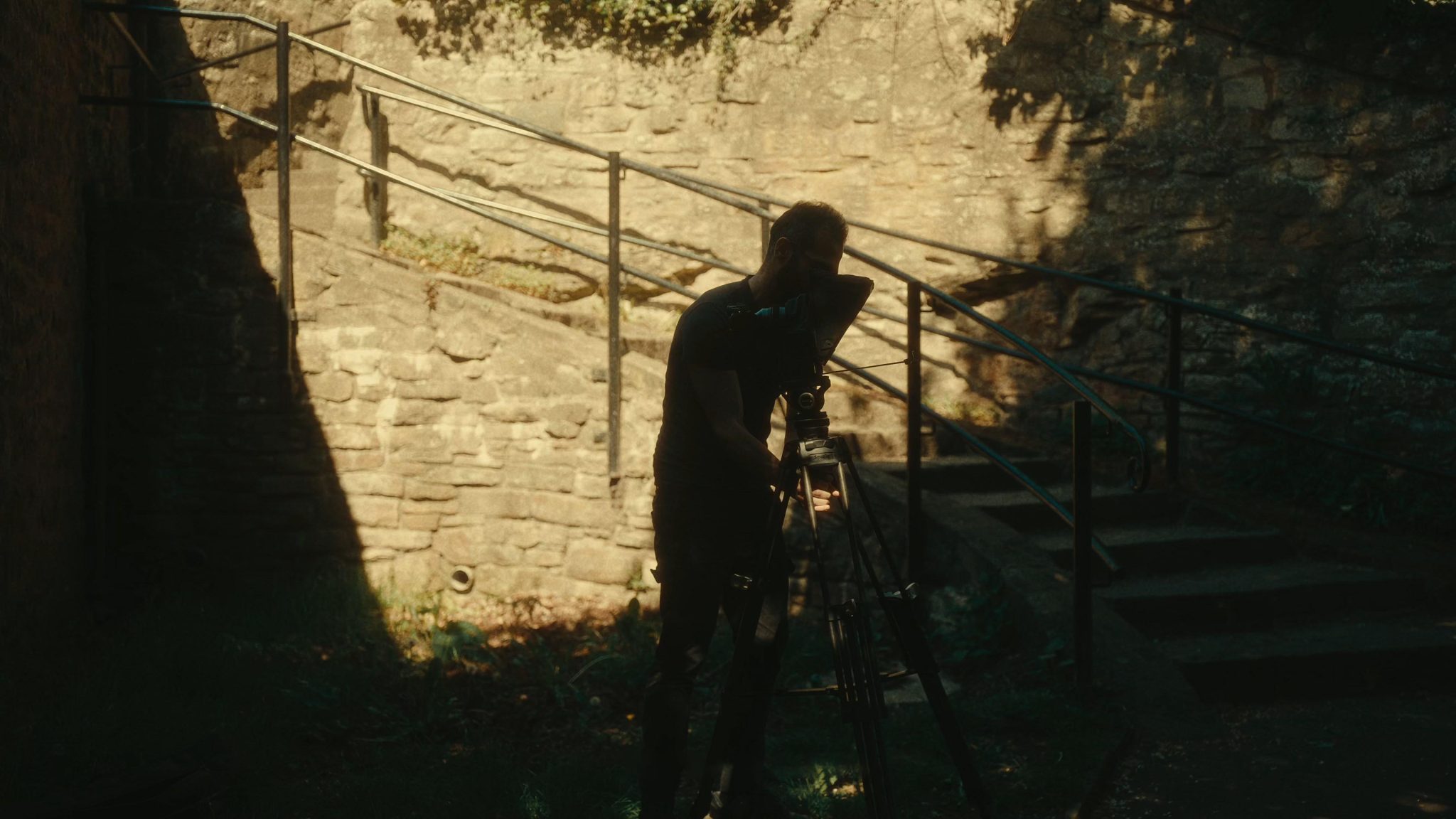 production - filmmaker setting up tripod