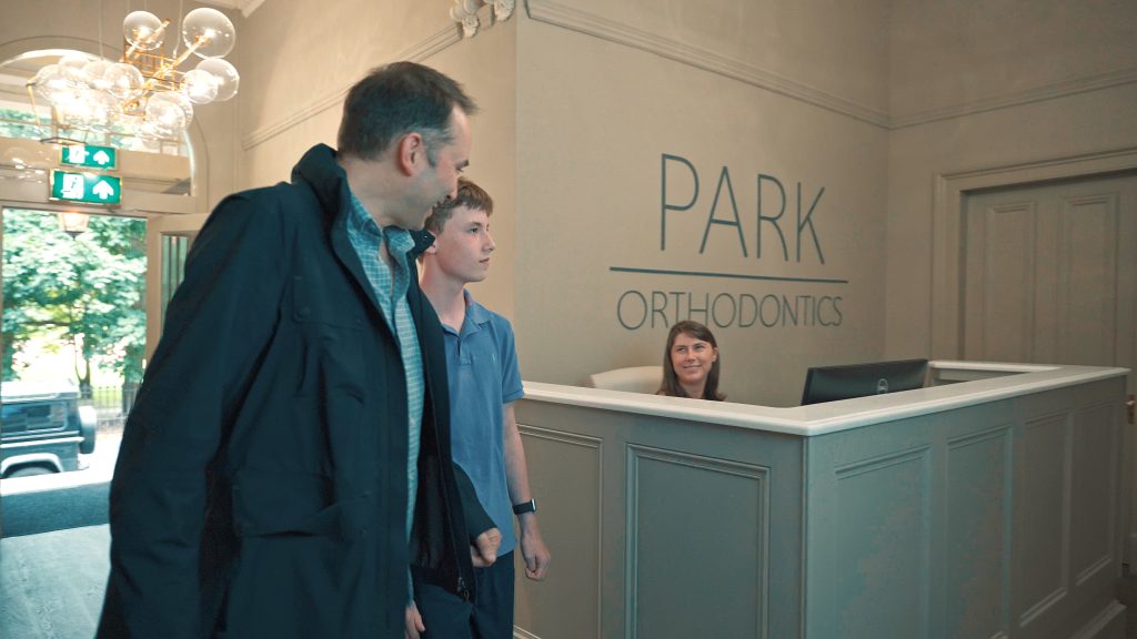 parent and son entering an orthodontics practice for a promotional video