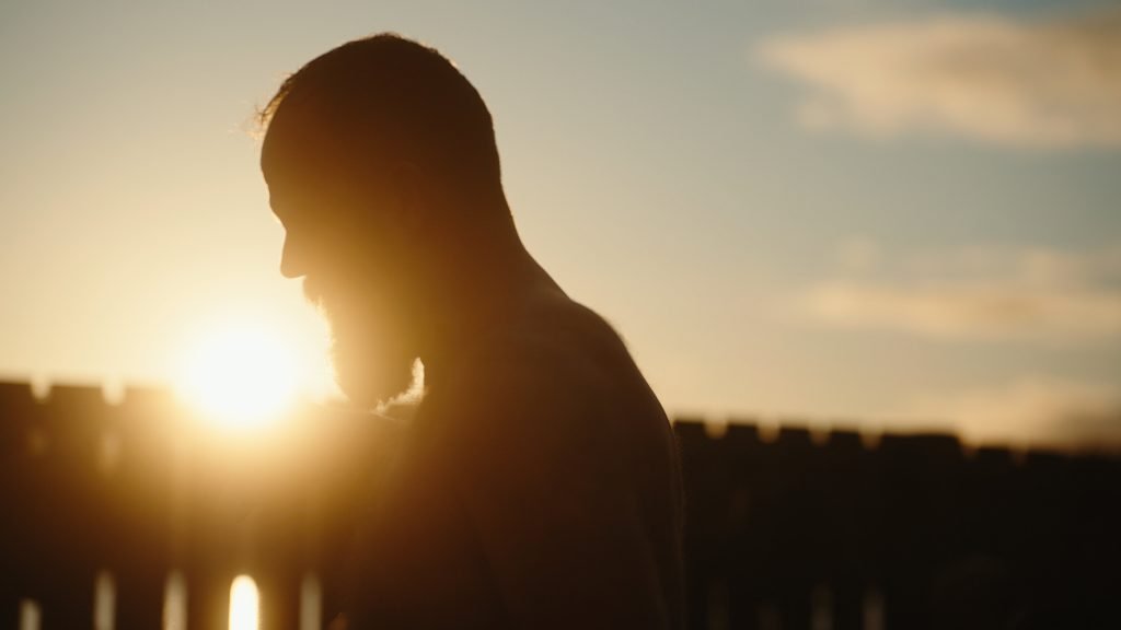 still from the short documentary Edinburgh blue balls mental health, a man silhouette, in a loch at sunset